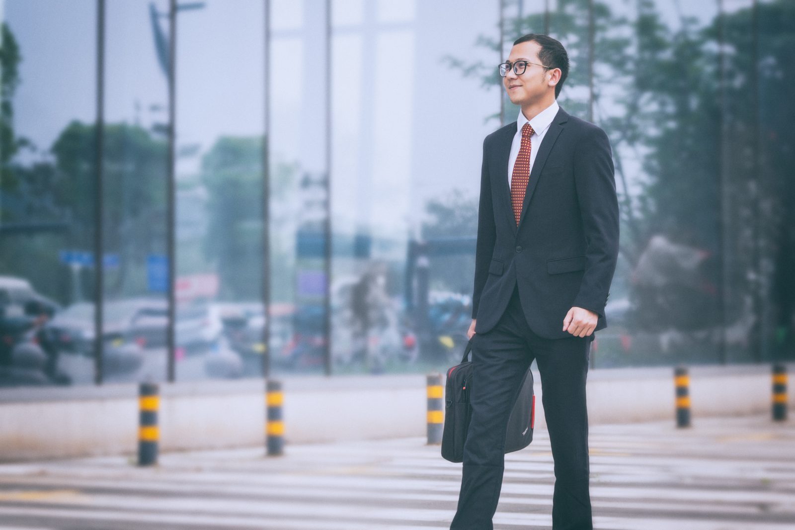 Professional with a briefcase crossing a city street