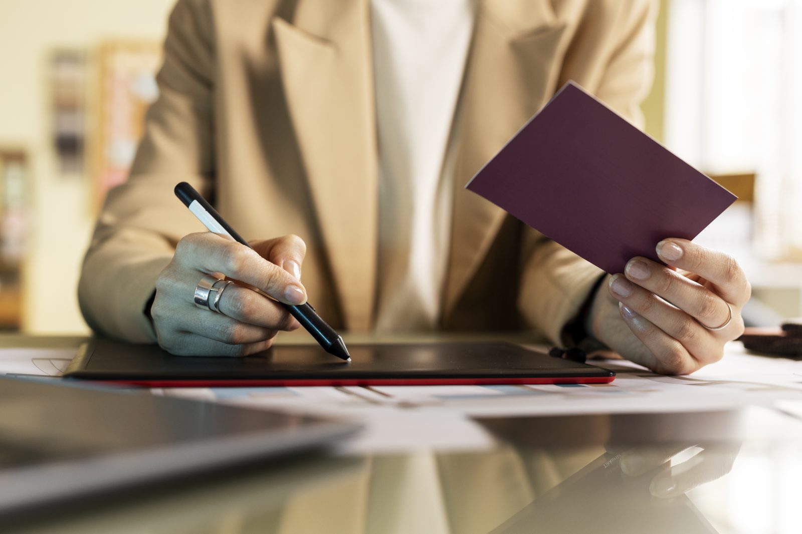 Hands signing a document next to a passport